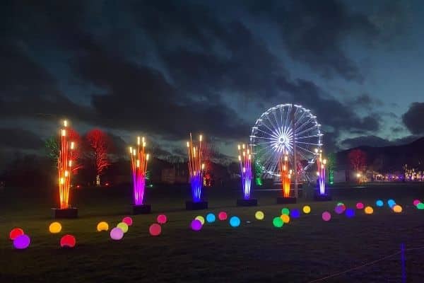 illuminated light orbs and giant observation wheel lit up at night.