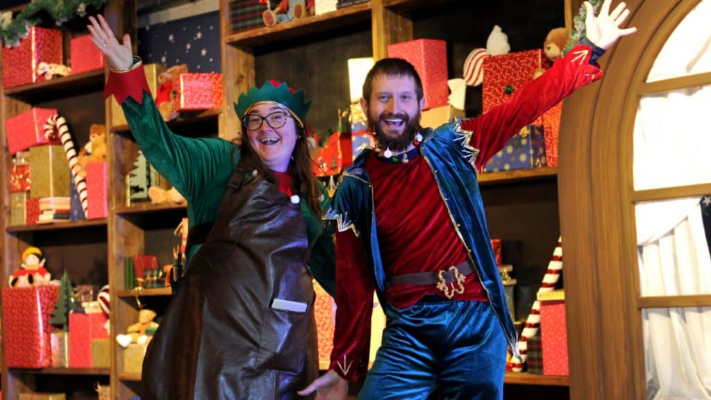 Two elves posing for a photo in Santa's Toy Workshop