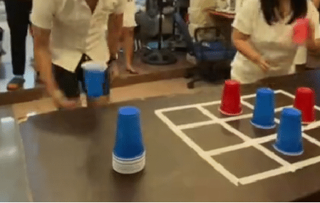 Flip Cup Tic Tac Toe players competing on a table